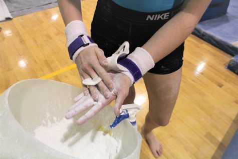 Brooks Lahr, 9, prepares her hands for practice by covereing them in chalk.