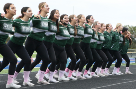 The varsity cheerleading team stands together and gets ready to chant in unison. Senior Marisa Myron (on the very left) says her favorite cheer is “ ‘Go Big Green!’ because it involves crowd interaction and that’s always really fun. You always want everyone else to feel just as excited as you.” 