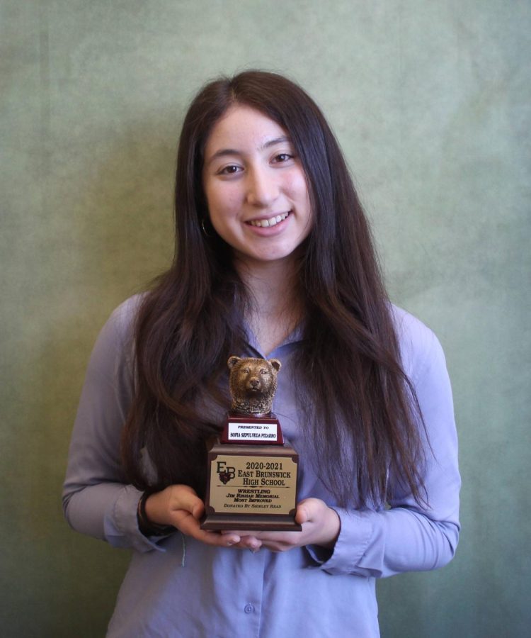 Sofia smiles and shows off her Jim Rishar Memorial Most Improved award for wrestling. 