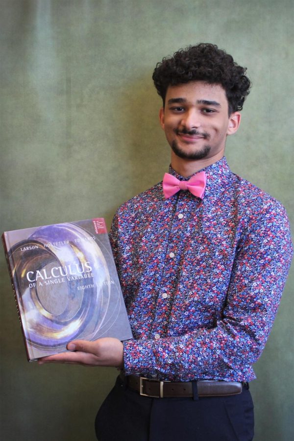 Mark Shenouda, 12,  holds up a calculus book that he can use for engineering.  Many classes at EBHS have helped Mark discover his passion for Computer Engineering.