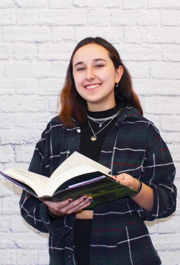 Senior Isabella Laszlo holds up one of her favorite books from the Harry Potter series to express her passion for reading. 