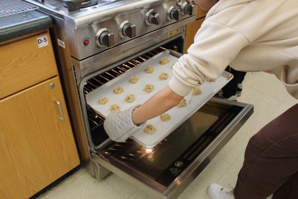 Joy Fouad (12) sends her groups cookie dough into the oven for baking. 